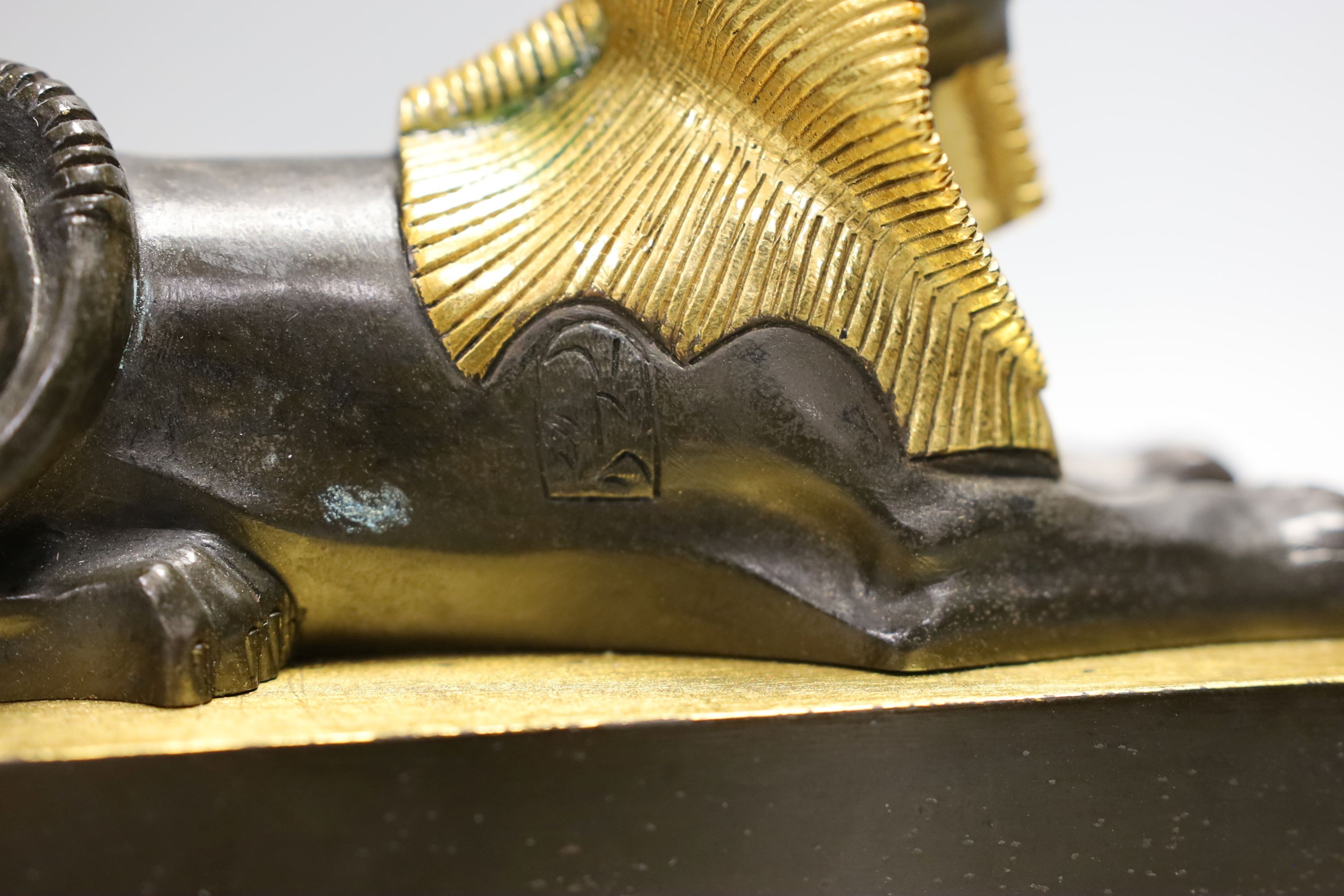 A parcel gilt bronze model of a sphinx on a Siena marble base - 22cm long